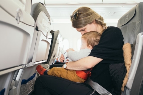 a mother holding a baby on the plane