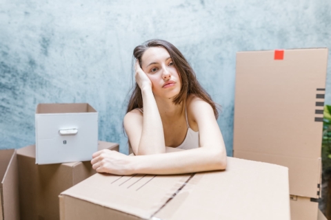 A woman without energy surrounded by boxes 